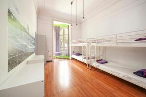 バルセロナにあるFabrizzios Terrace Hostelの二段ベッド2台と廊下が備わる客室です。