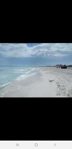 a picture of a beach with footprints in the sand at Residence Anis mnakaa in Sīdī ‘Ulwān