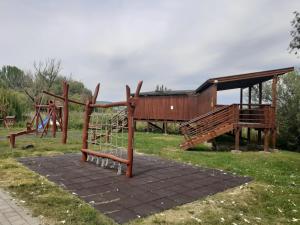um parque infantil num parque com uma estrutura de madeira em KARDOS APARTMAN em Csopak