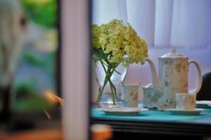wazon wypełniony kwiatami na stole w obiekcie Friendly Place Doki w Gdańsku