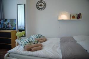 um quarto com uma cama com um relógio na parede em Friendly Place Doki em Gdańsk