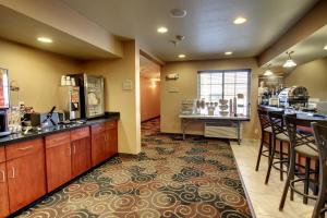 a kitchen with a counter and a bar with stools at Cobblestone Inn & Suites - Bottineau in Bottineau
