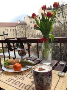 een tafel met een bord eten en een vaas met bloemen bij Greg&Tom Hostel in Krakau