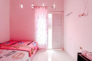 Postel nebo postele na pokoji v ubytování Pinky Guest House Syariah Kota Batu