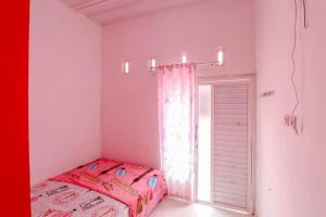 Postel nebo postele na pokoji v ubytování Pinky Guest House Syariah Kota Batu