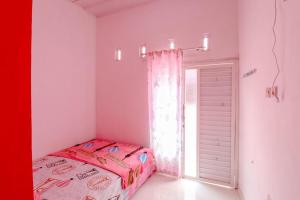 Postel nebo postele na pokoji v ubytování Pinky Guest House Syariah Kota Batu