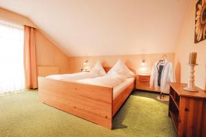 een slaapkamer met een groot houten bed in een kamer bij Landhaus Kreileder in Bad Griesbach