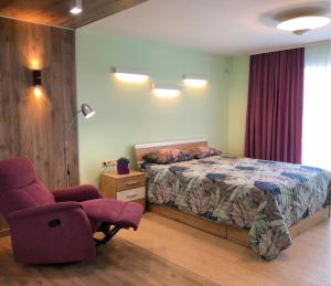 1 dormitorio con 1 cama, 1 silla y 1 lámpara en Kotsubinsky street LUX Apartment en Vínnytsia