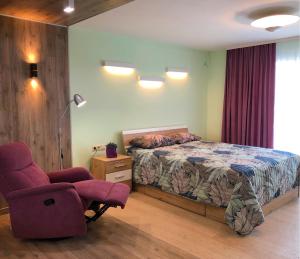 a bedroom with a bed and a chair and a lamp at Comfy Retreat on Kotsubinsky street in Vinnytsya