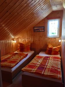 dwa łóżka w drewnianym pokoju z oknem w obiekcie Ferienhäuser mit Pool w Rewalu