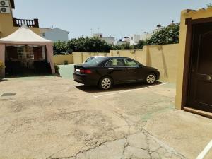a black car parked in a parking lot at Hotel Riavela in Ayamonte