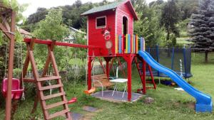 een speeltuin met een speelhuis en een glijbaan bij Cottage Forest Stream in Visoko
