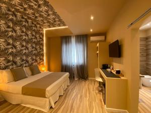 una camera d'albergo con letto e TV di Harmony House Prestige a Pisa