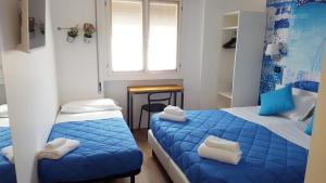 サロにあるLake Garda Hostelのベッド2台と窓が備わる小さな客室です。