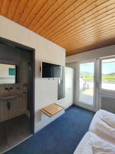 a bedroom with a bed and a bathroom with a television at Erlebnisland Grizzlybär in Längenbühl 