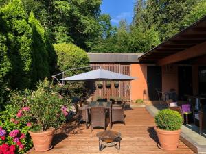 eine Terrasse mit einem Sonnenschirm, Stühlen und Blumen in der Unterkunft Haus Graf Velden in Velden am Wörthersee