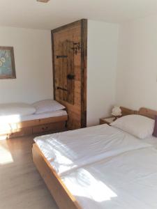 a bedroom with two beds and a wooden door at Landhaus Manuela & Haus Michael in Leutasch