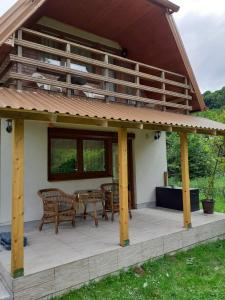 een huis met een terras en een tafel en stoelen bij Cottage Forest Stream in Visoko