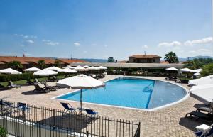 uma piscina com guarda-sóis e cadeiras e um resort em Agriturismo Cannavota em Follonica