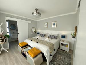 a bedroom with a large white bed with yellow pillows at Paradise Found, Paradise Beach, Jeffreys Bay in Jeffreys Bay