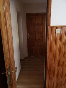 a hallway with a wooden door and a wooden floor at Wypoczynek Roda in Pobierowo
