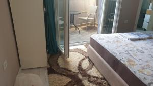 Schlafzimmer mit einem Bett und einer Glasschiebetür in der Unterkunft Apartman Sweet Dreams 3 in Niš