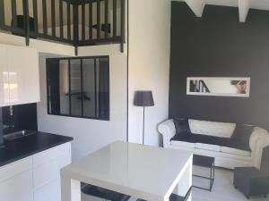 eine Küche und ein Wohnzimmer mit einem Tisch und einem Sofa in der Unterkunft T2 Bis Design et Lumineux à 200m du Village Naturiste in Cap d'Agde