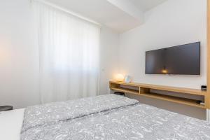 a bedroom with a bed and a flat screen tv at Apartment LAURUS in Krk