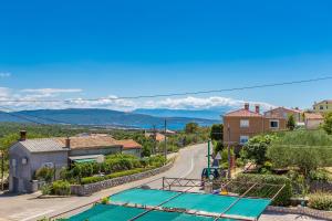 a street in a small village with mountains in the background at Apartment LAURUS in Krk