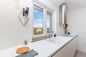 a white kitchen with a sink and a window at Apartment LAURUS in Krk +18 photos