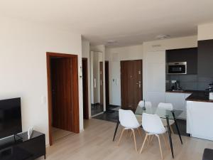 a living room with a table and white chairs at GalériusPrémium8 in Siófok