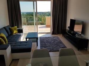 a living room with a blue couch and a tv at GalériusPrémium8 in Siófok