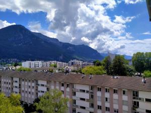 una vista di un edificio con le montagne sullo sfondo di Appartement à 300 m du lac et des commerces ad Annecy