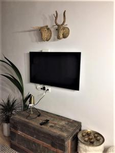TV de pantalla plana en la pared con cofre de madera en Seqo Loft, en Toledo