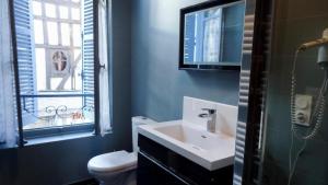 baño con lavabo y aseo y ventana en Le Pan de Bois, en Bar-sur-Seine