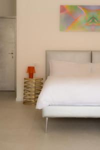- une chambre avec un lit blanc et une peinture murale dans l'établissement Emma Suite Merano, à Merano