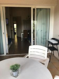グリモーにあるLES RESTANQUES DE SAINT-TROPEZのリビングルーム(白いテーブルと椅子付)