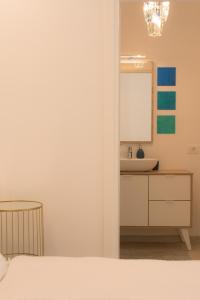 a bathroom with a bed and a sink and a mirror at Emma Suite Merano in Merano +35 photos