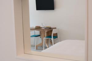 a table and chairs in a room with a mirror at Emma Suite Merano in Merano