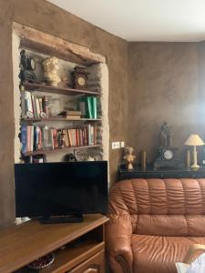 un soggiorno con TV e divano di Le CASTELOU d'IDA a Saint-Julien-Gaulène
