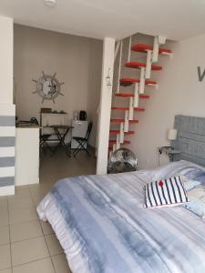 ein Schlafzimmer mit einer Treppe neben einem Bett in der Unterkunft Le petit Radieux in Gémozac