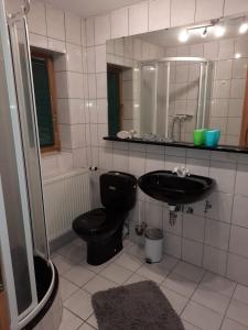 a bathroom with a black toilet and a sink at Urlauben, da wo der Geist wohnt in Eging
