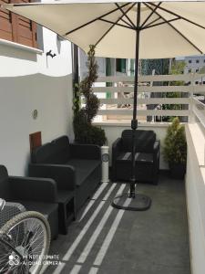 a patio with chairs and an umbrella on a balcony at La Casa di Bea in Magliano deʼ Marsi