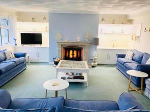 a living room with blue couches and a fireplace at Tremarne Hotel in Mevagissey
