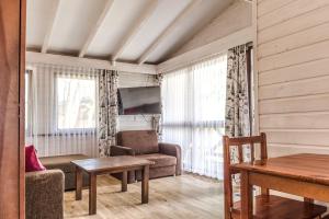 a living room with a couch and a table at Ośrodek Wczasowy Leśny Resort Mielno in Mielno