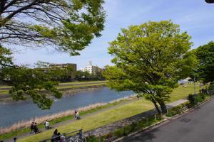 people walking along a path next to a river at Saigawa House in Kanazawa