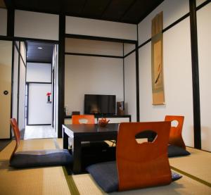 a living room with a table and chairs and a television at Saigawa House in Kanazawa