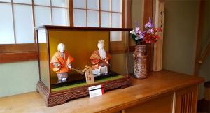a figurine of two people in a glass box on a table at Hida House in Takayama