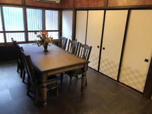 a dining room table with chairs and a vase of flowers on it at Taisho Aburaya in Takayama