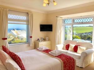 a hotel room with two beds and a television at Tremarne Hotel in Mevagissey